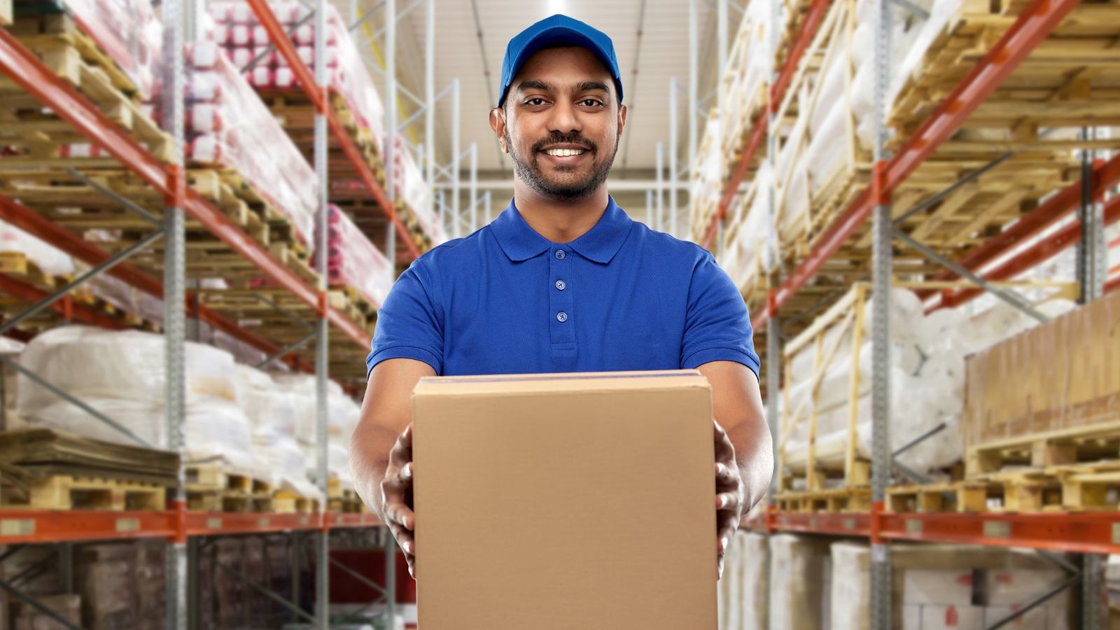 Warehouse operative handing over a carton in a racked distribution facility